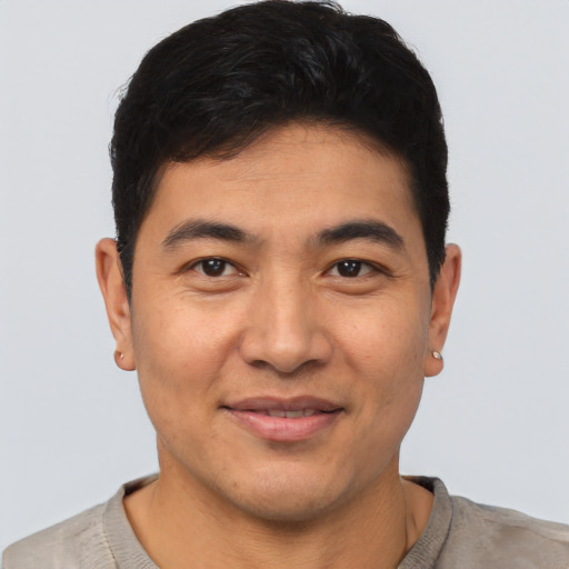 Joyful asian young-adult male with short  brown hair and brown eyes