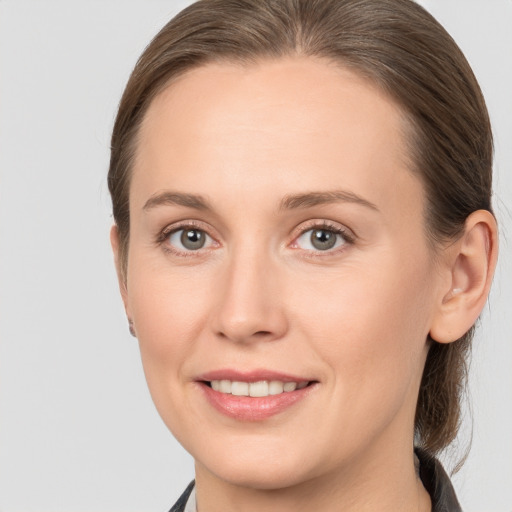 Joyful white young-adult female with medium  brown hair and grey eyes