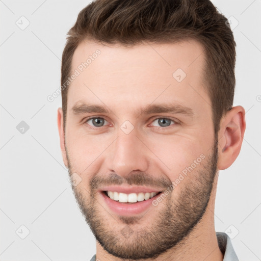 Joyful white young-adult male with short  brown hair and grey eyes