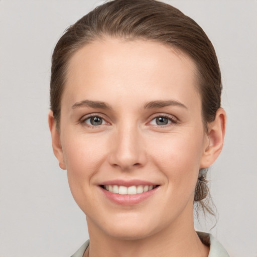 Joyful white young-adult female with short  brown hair and grey eyes