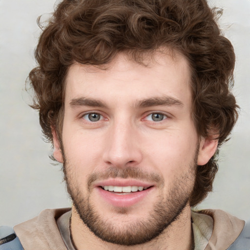 Joyful white young-adult male with short  brown hair and blue eyes