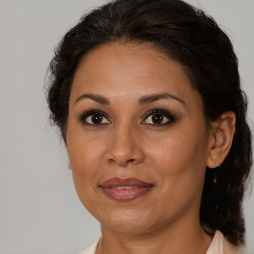 Joyful latino adult female with medium  brown hair and brown eyes