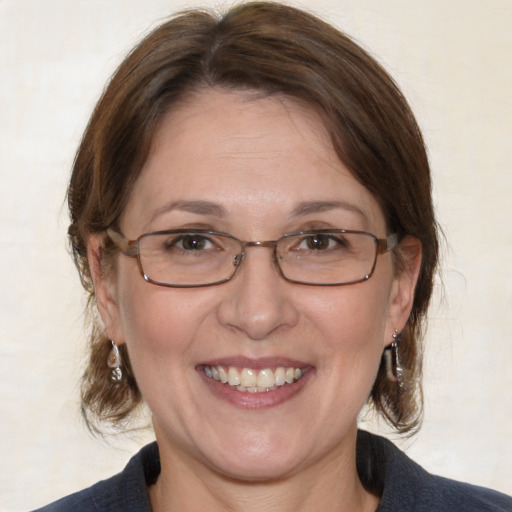 Joyful white adult female with medium  brown hair and blue eyes