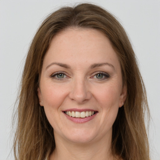 Joyful white adult female with long  brown hair and green eyes