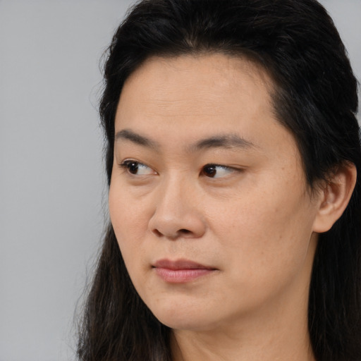 Joyful asian young-adult female with long  brown hair and brown eyes