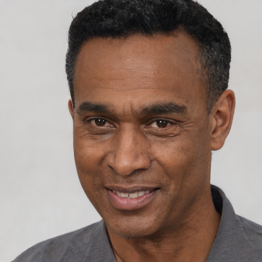 Joyful black adult male with short  black hair and brown eyes