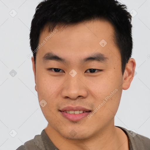 Joyful asian young-adult male with short  brown hair and brown eyes