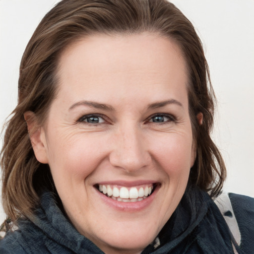 Joyful white young-adult female with medium  brown hair and blue eyes