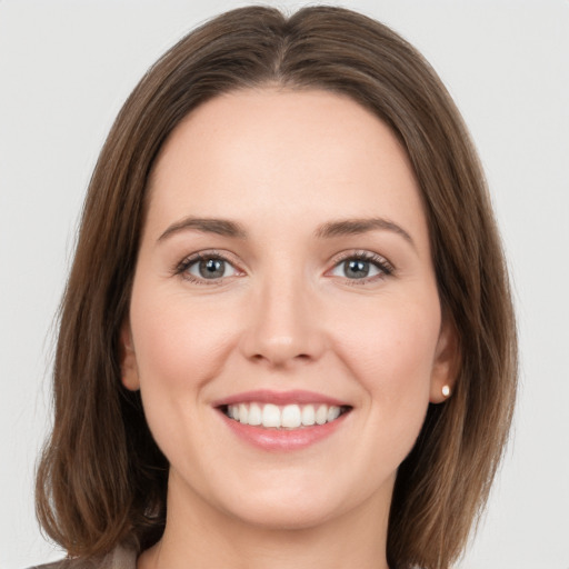 Joyful white young-adult female with long  brown hair and green eyes