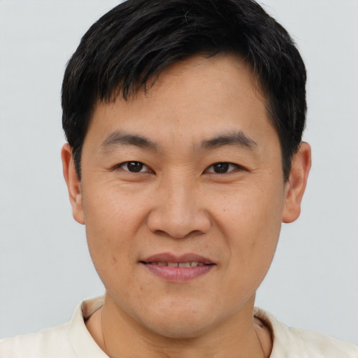 Joyful asian young-adult male with short  brown hair and brown eyes