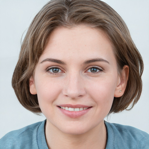 Joyful white young-adult female with medium  brown hair and blue eyes