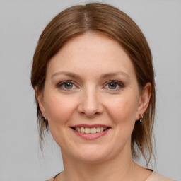 Joyful white young-adult female with medium  brown hair and grey eyes