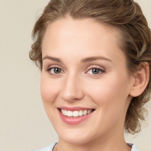 Joyful white young-adult female with medium  brown hair and blue eyes