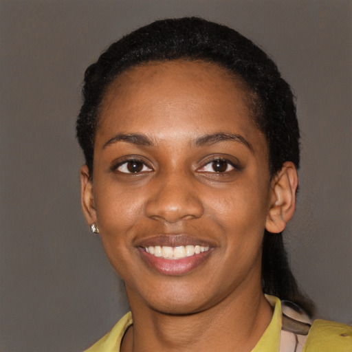 Joyful black young-adult female with short  black hair and brown eyes