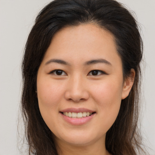 Joyful asian young-adult female with long  brown hair and brown eyes