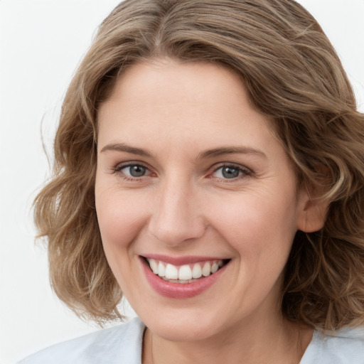 Joyful white young-adult female with medium  brown hair and green eyes