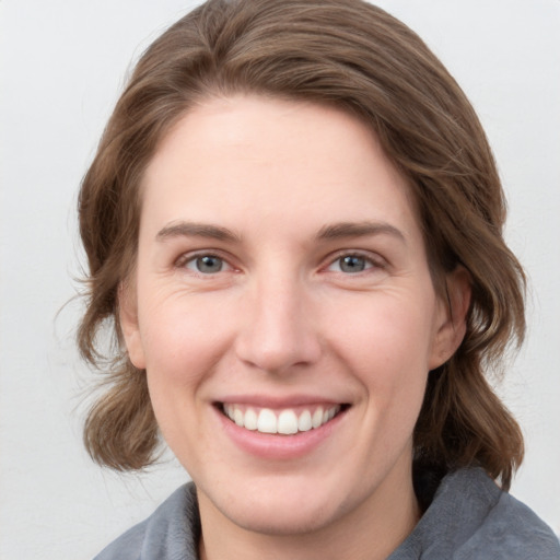 Joyful white young-adult female with medium  brown hair and blue eyes