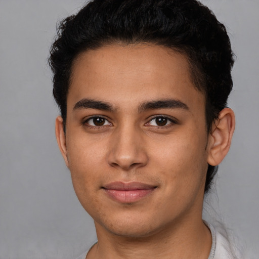 Joyful latino young-adult male with short  brown hair and brown eyes