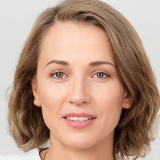 Joyful white young-adult female with medium  brown hair and green eyes