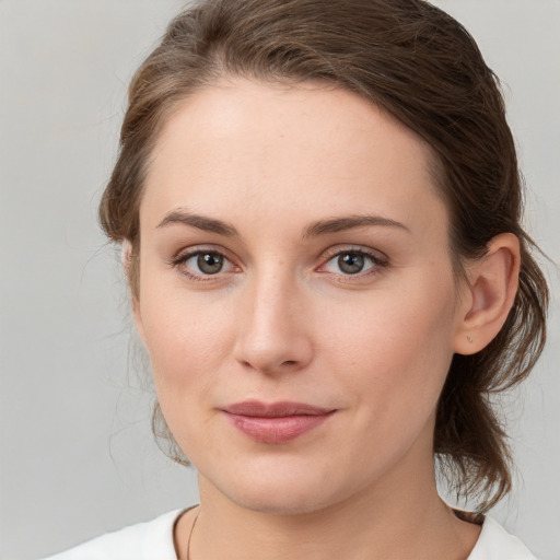 Joyful white young-adult female with medium  brown hair and green eyes