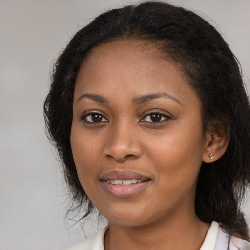 Joyful black young-adult female with long  black hair and brown eyes