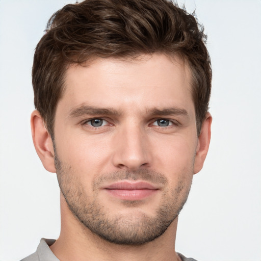 Joyful white young-adult male with short  brown hair and grey eyes