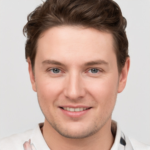 Joyful white young-adult male with short  brown hair and grey eyes