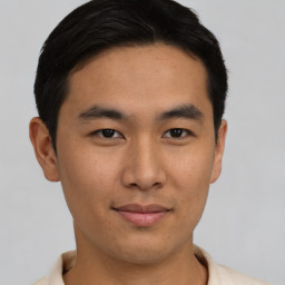 Joyful asian young-adult male with short  black hair and brown eyes