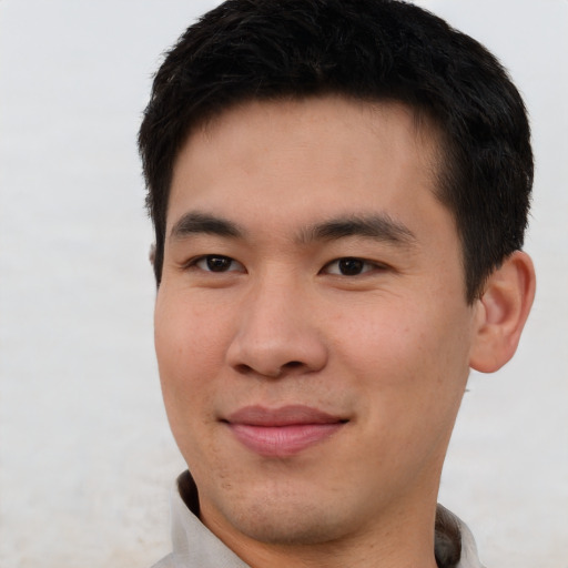 Joyful asian young-adult male with short  brown hair and brown eyes