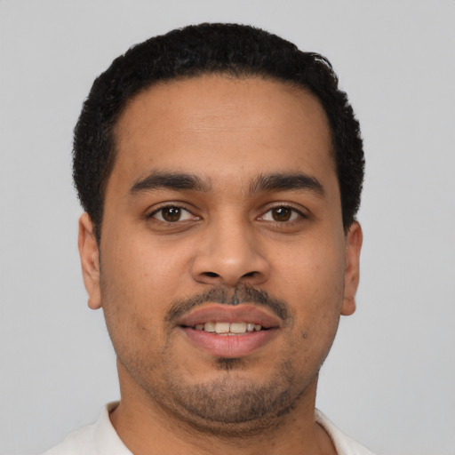 Joyful latino young-adult male with short  black hair and brown eyes