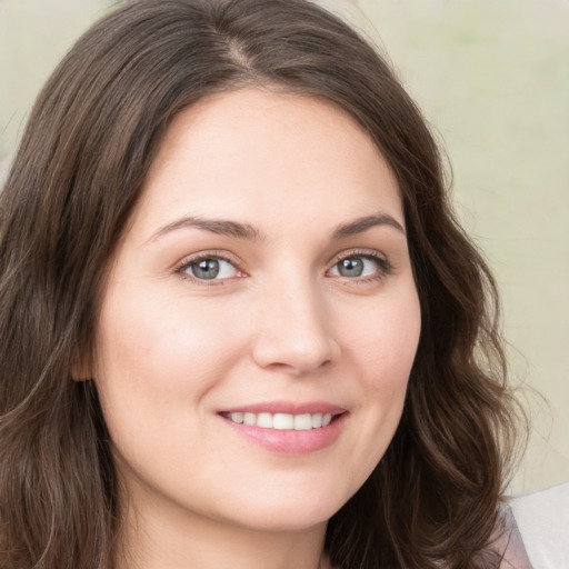 Joyful white young-adult female with long  brown hair and green eyes