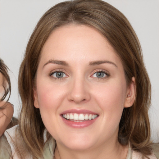 Joyful white young-adult female with medium  brown hair and green eyes