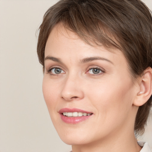 Joyful white young-adult female with medium  brown hair and grey eyes