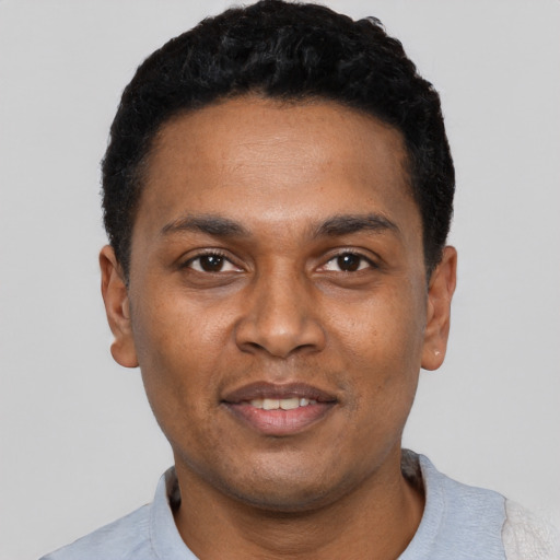 Joyful black young-adult male with short  black hair and brown eyes