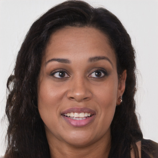 Joyful black young-adult female with long  brown hair and brown eyes