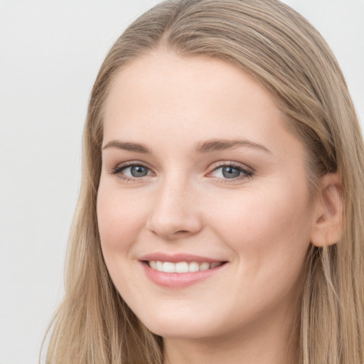 Joyful white young-adult female with long  brown hair and blue eyes