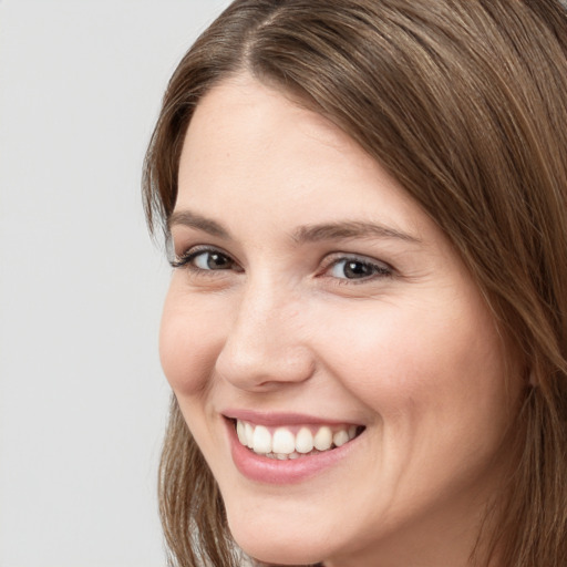 Joyful white young-adult female with long  brown hair and grey eyes