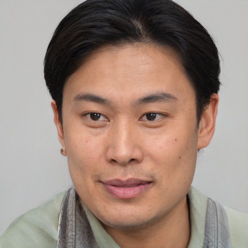 Joyful asian young-adult male with short  brown hair and brown eyes