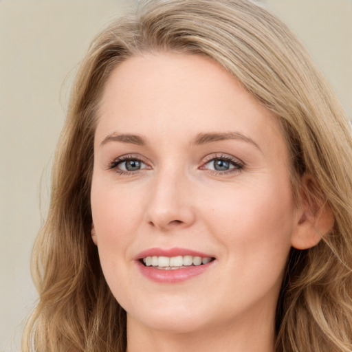 Joyful white young-adult female with long  brown hair and blue eyes