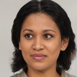 Joyful black adult female with medium  brown hair and brown eyes