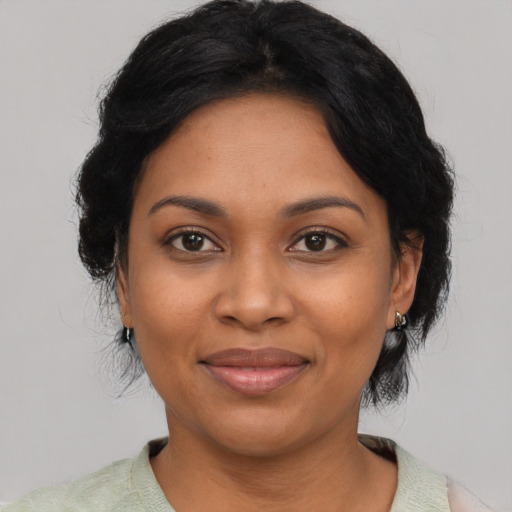 Joyful black adult female with medium  black hair and brown eyes