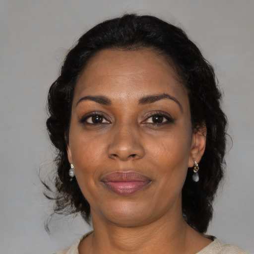 Joyful black adult female with medium  brown hair and brown eyes