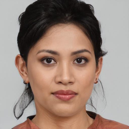 Joyful latino young-adult female with medium  brown hair and brown eyes