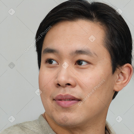 Joyful asian young-adult male with short  black hair and brown eyes