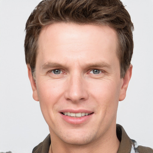 Joyful white young-adult male with short  brown hair and grey eyes