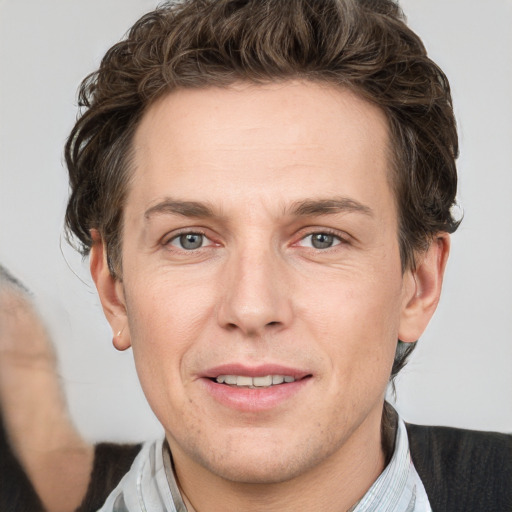 Joyful white adult male with short  brown hair and grey eyes