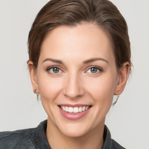 Joyful white young-adult female with medium  brown hair and grey eyes