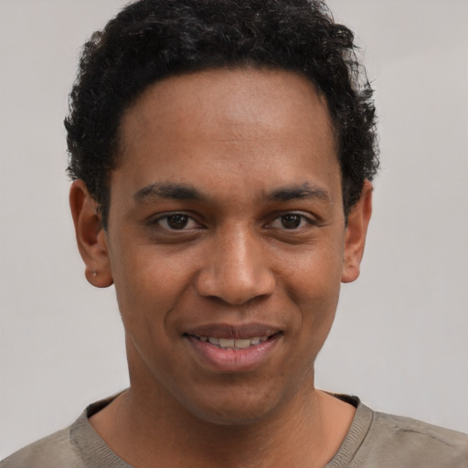 Joyful black young-adult male with short  brown hair and brown eyes