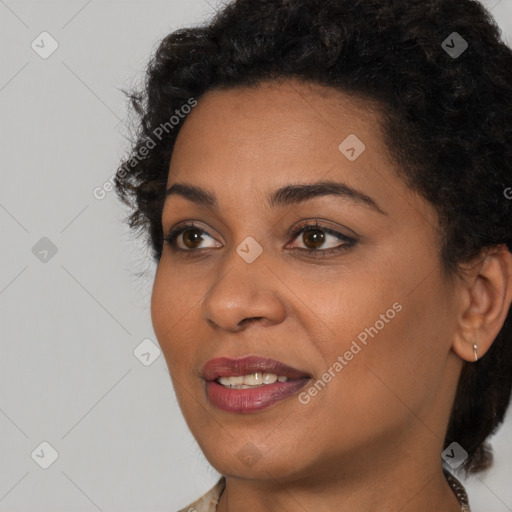 Joyful black young-adult female with long  brown hair and brown eyes