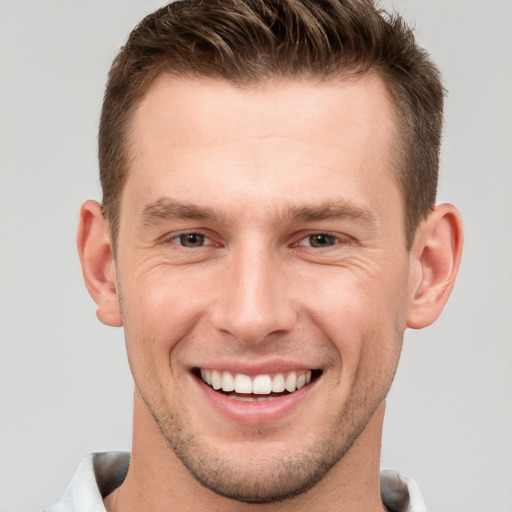 Joyful white young-adult male with short  brown hair and brown eyes